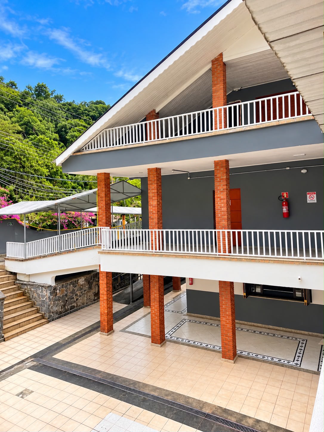 Fachada da unidade Arujá, com varandas amplas e vegetação ao redor.